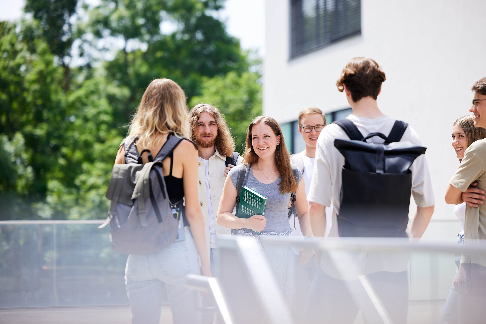 eine Gruppe junger Studenten unterhalten sich vor einer Stiege am Campus Hagenberg.