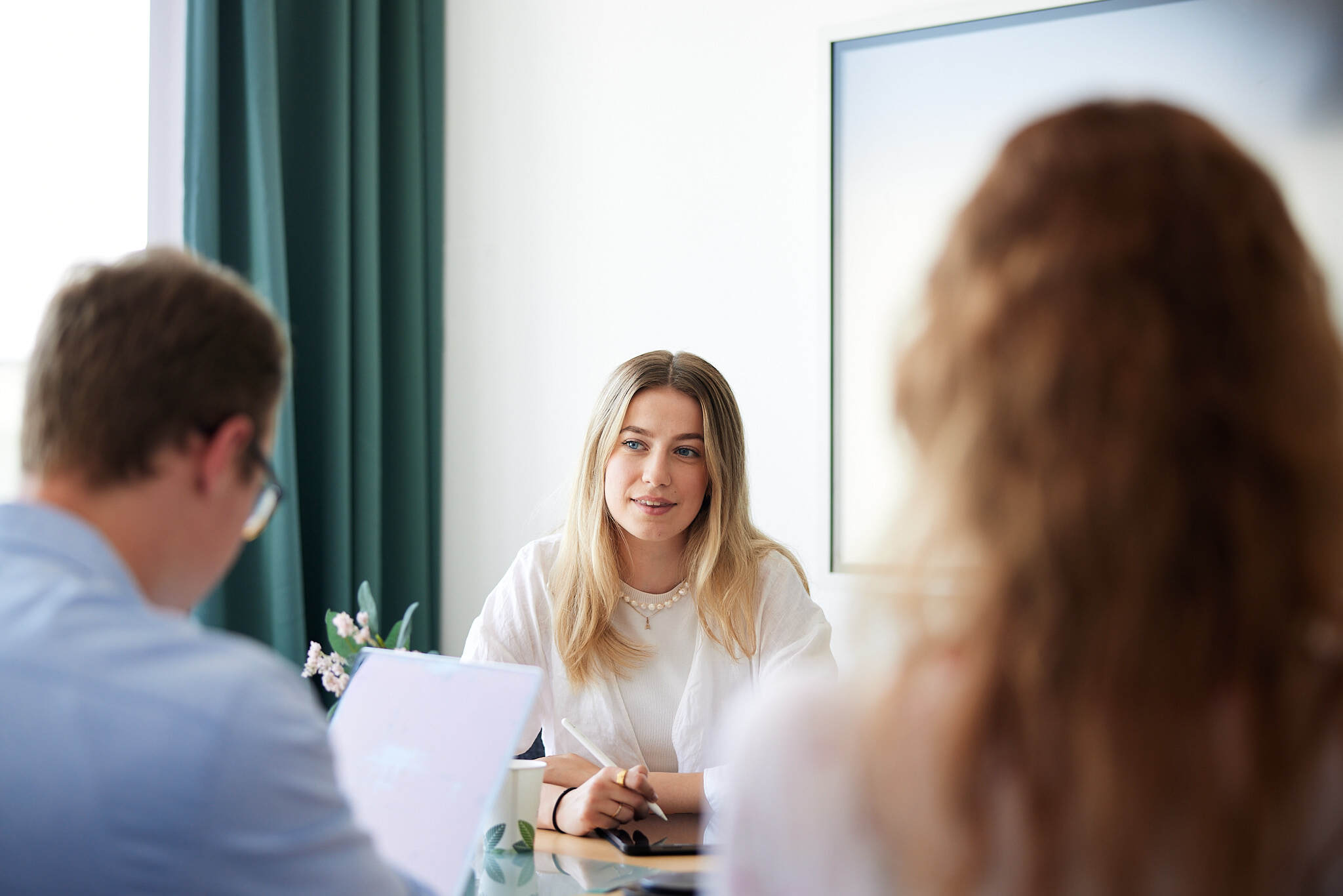 Eine junge Studenten ist im Zentrum im Fokus bei einer Besprechung. Die Anderen sind jeweils links und rechts von ihr unscharf