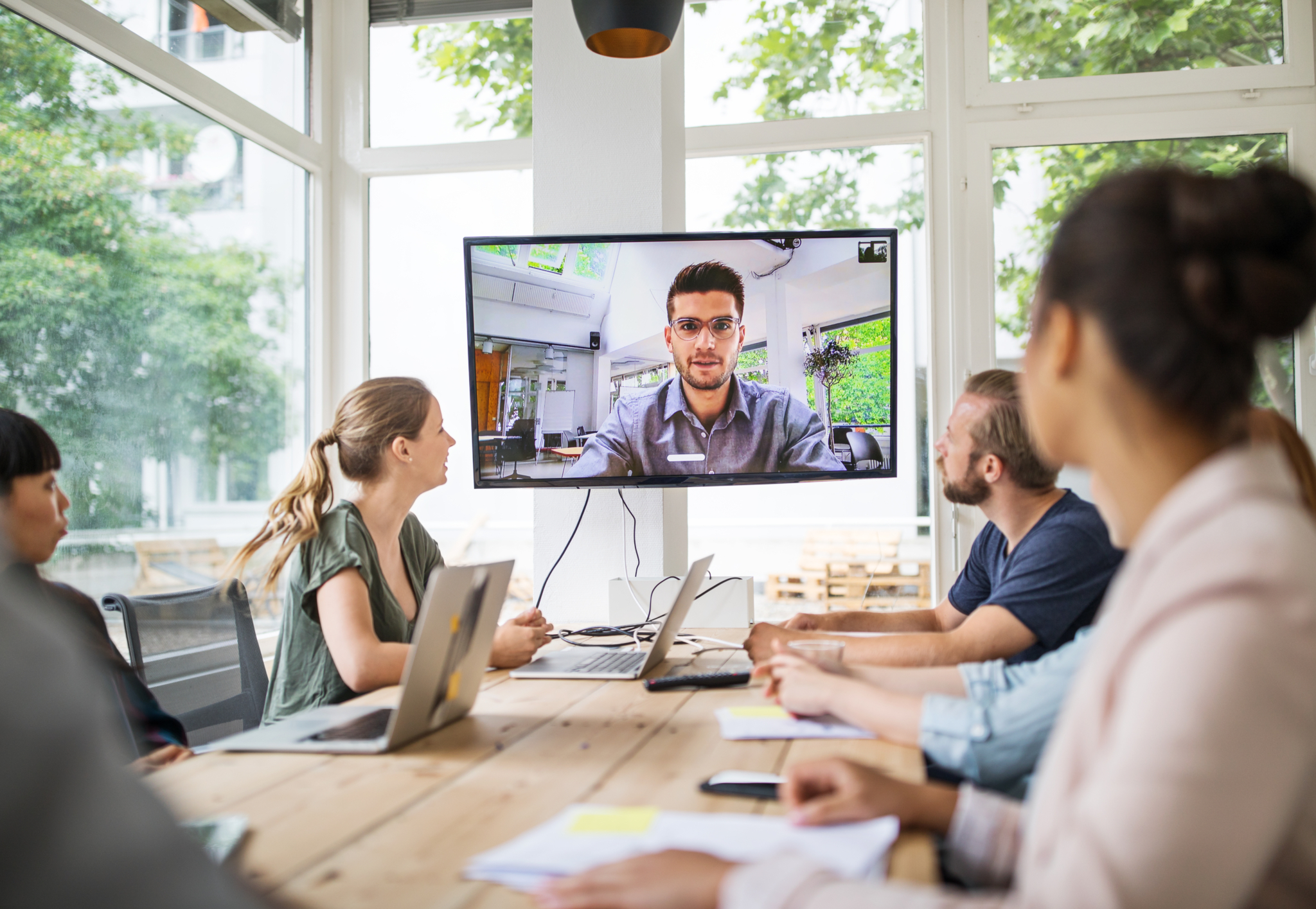 Vier Personen sitzen vor einem Bildschirm und nehmen an einem Online-Workshop teil.