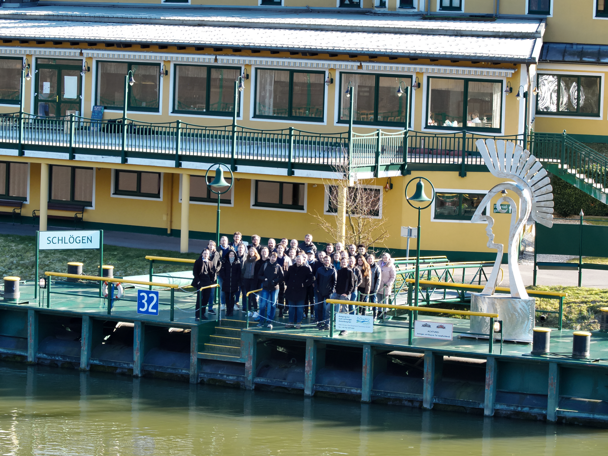Eine Gruppe von Mensschen stehen am Bootssteg und warten