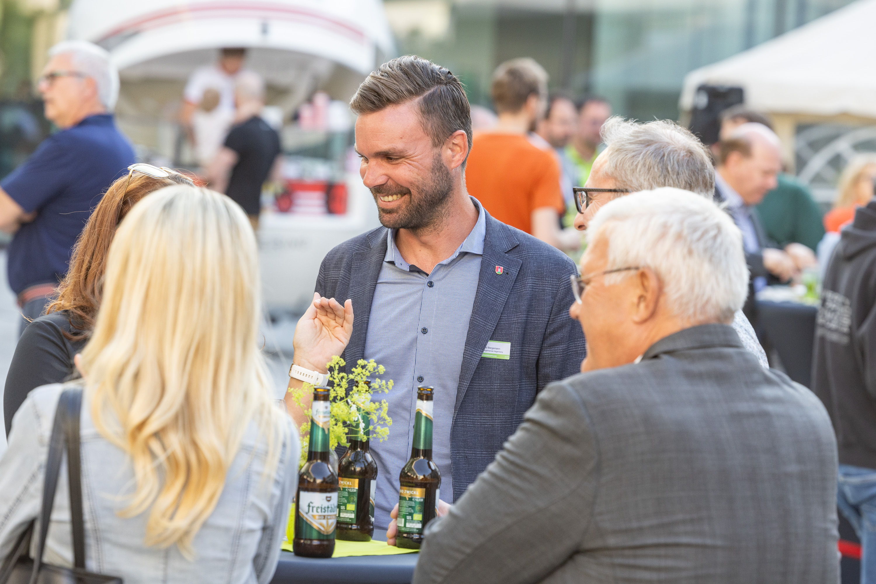 Gemütliche Unterhaltung von vier Personen an einem Stehtisch