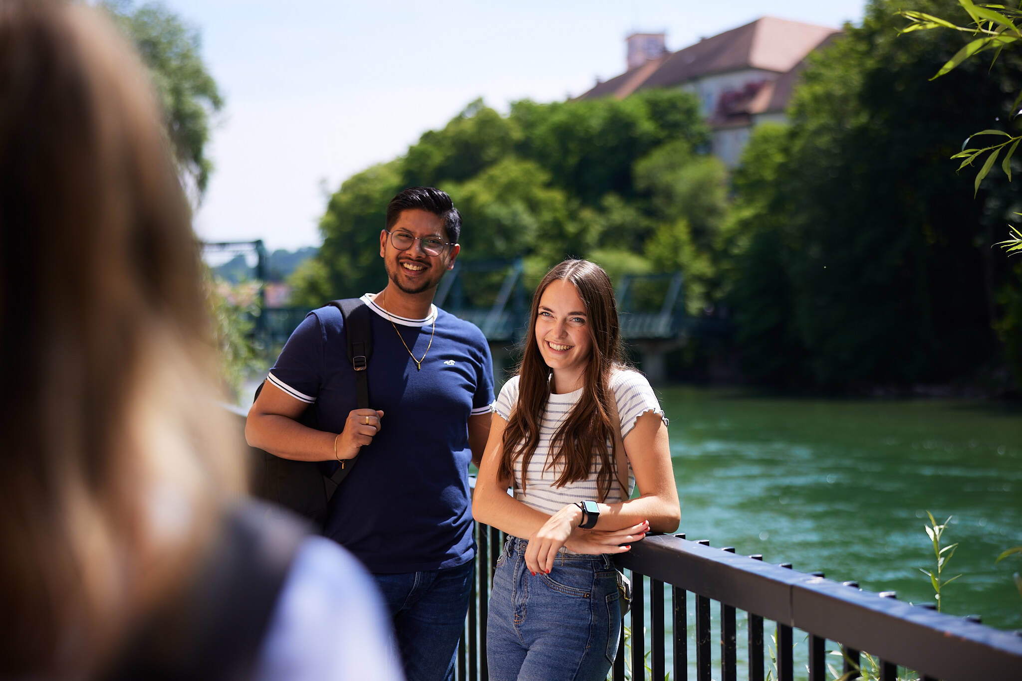 zwei junge Studenten stehen bei einem Geländer vor dem Fluss Steyr