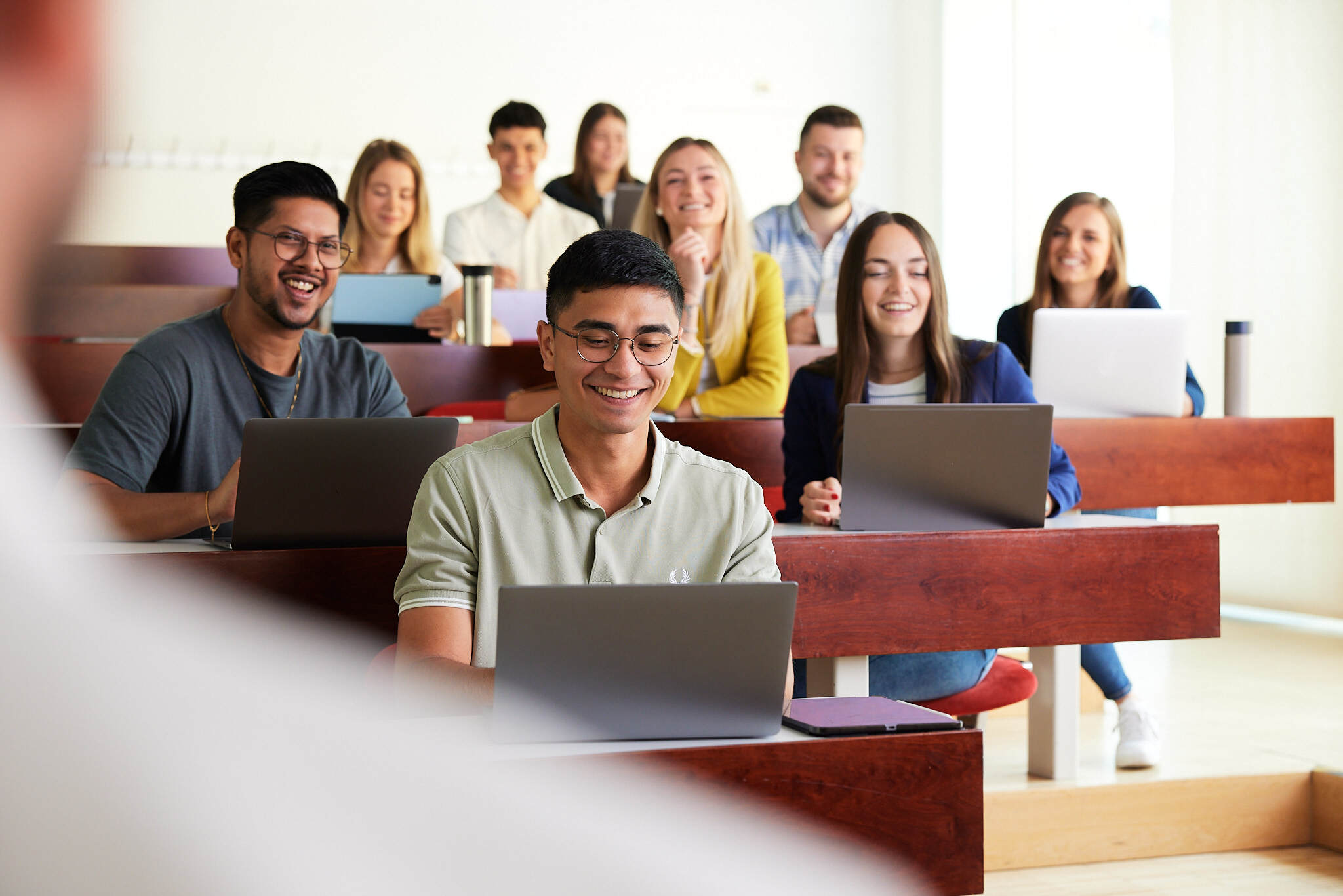 eine Gruppe junger Studenten sitzt vor ihren Laptops in einem Hörsaal der FH Steyr.