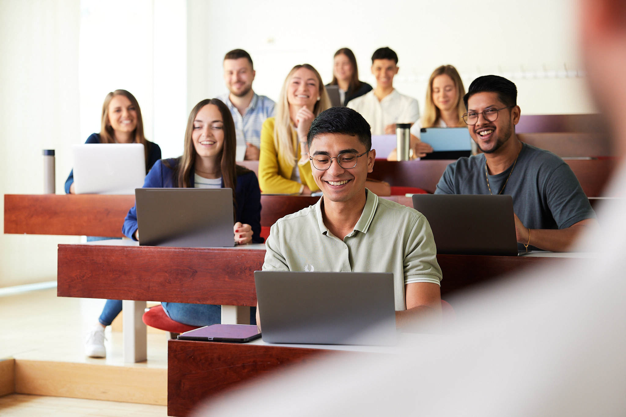 eine Gruppe junger Studenten sitzt vor ihren Laptops in einem Hörsaal der FH Campus Steyr.