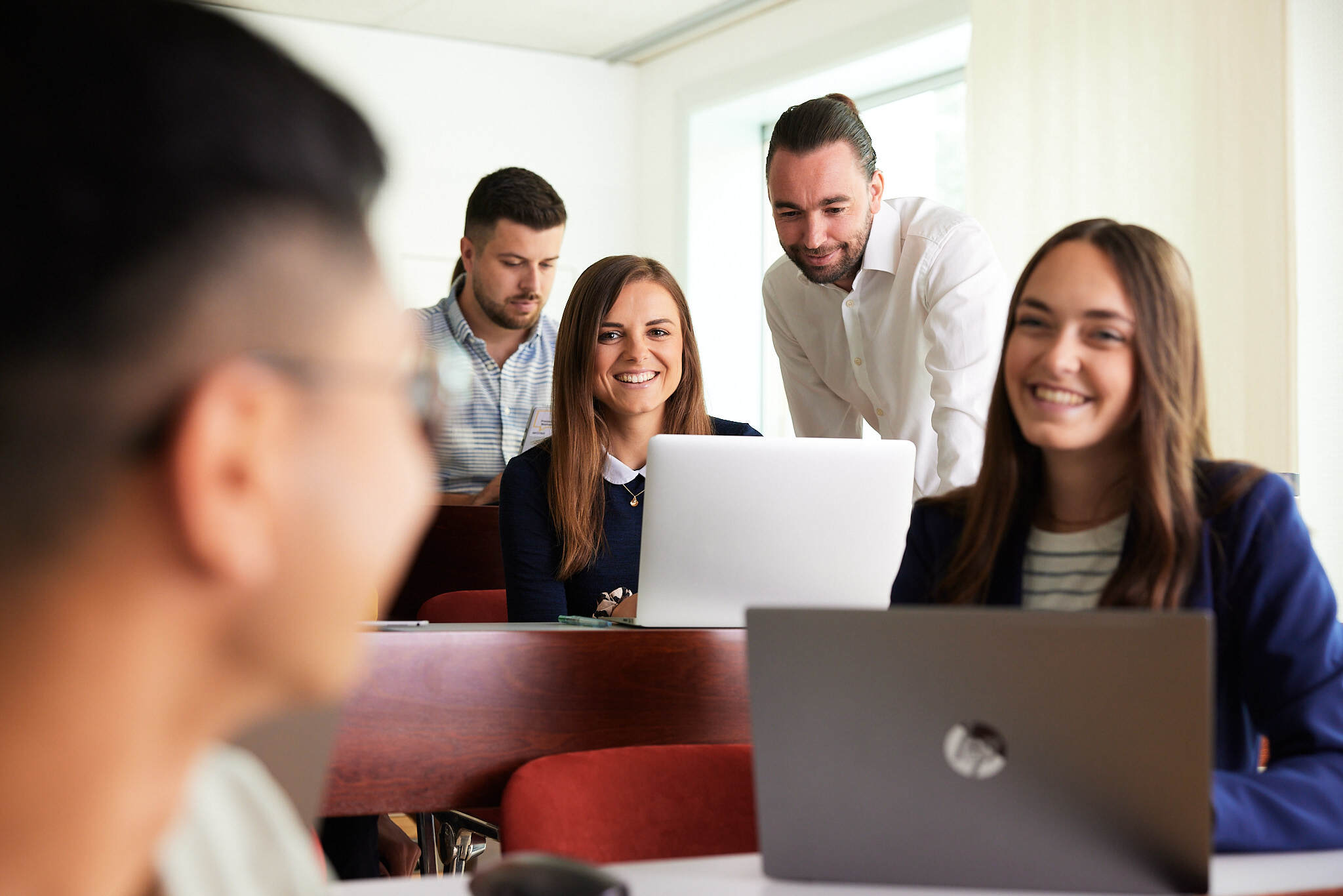 A group of young students sitting in front of their laptops in a lecture hall at Steyr Campus University of Applied Sciences,  Austria.