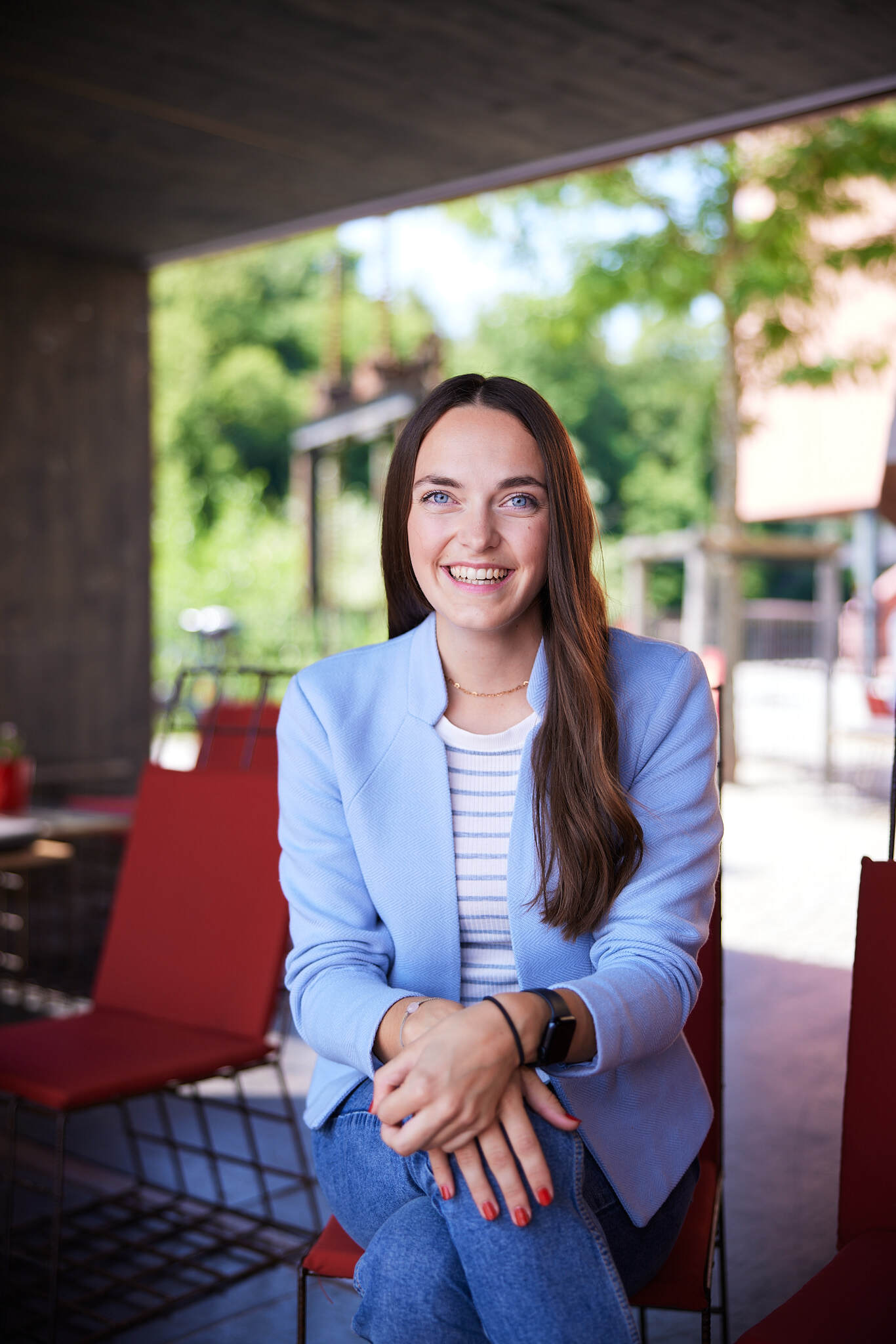 eine Studentin sitzt auf einem Stuhl in einem Outdoor-Bereich der FH Steyr