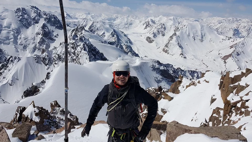 Ein Mann steht vor schneebedeckten Bergen