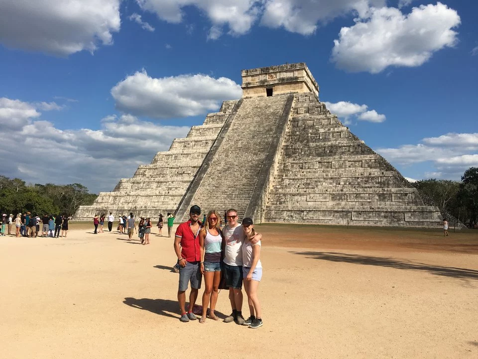 Eine Gruppe steht von einer großen Stufenpyramide