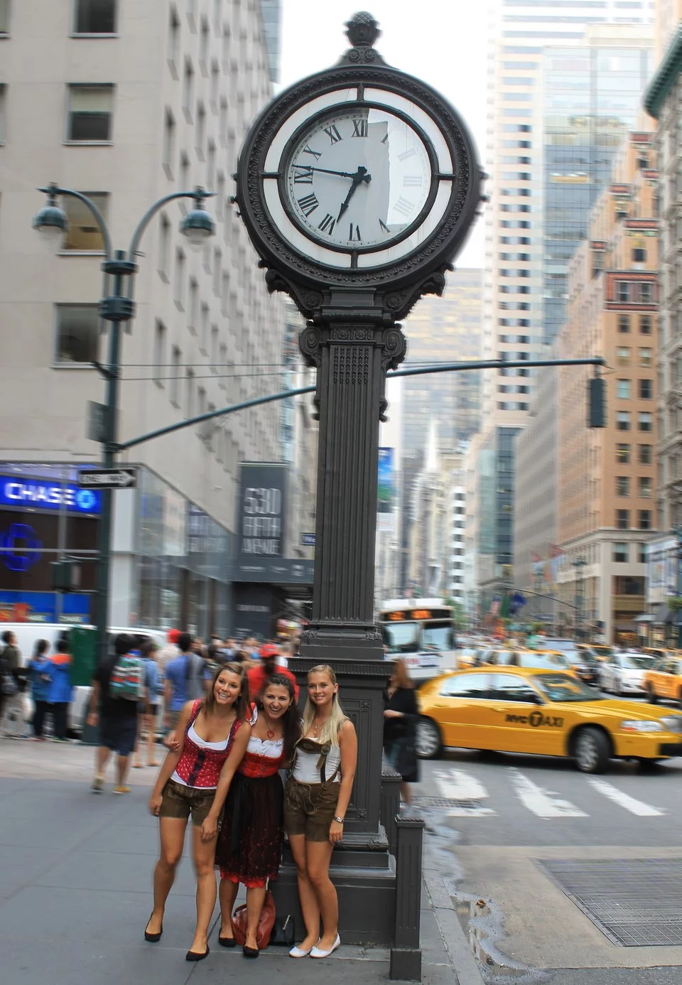 Drei junge Mädchen in traditioneller Tracht stehen auf einer Straße in New York City