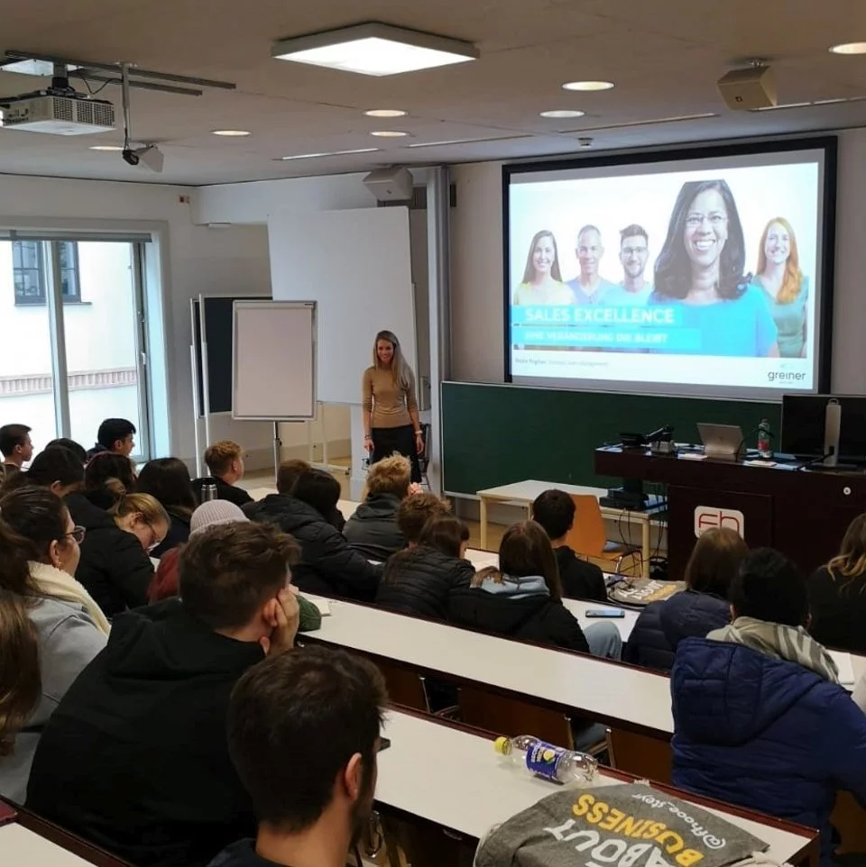 Personengruppe verfolgt aufmerksam eine Präsentation