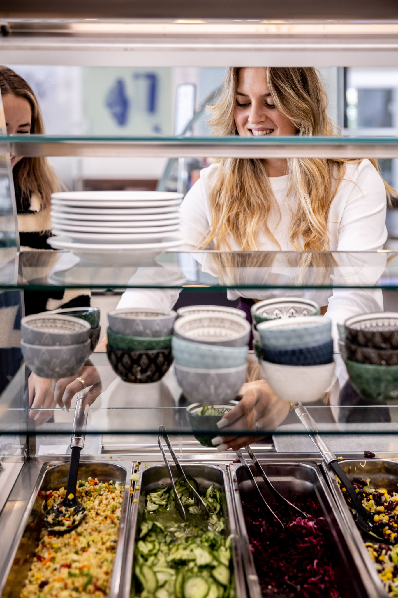 Studentin bedient sich beim Salatbuffet