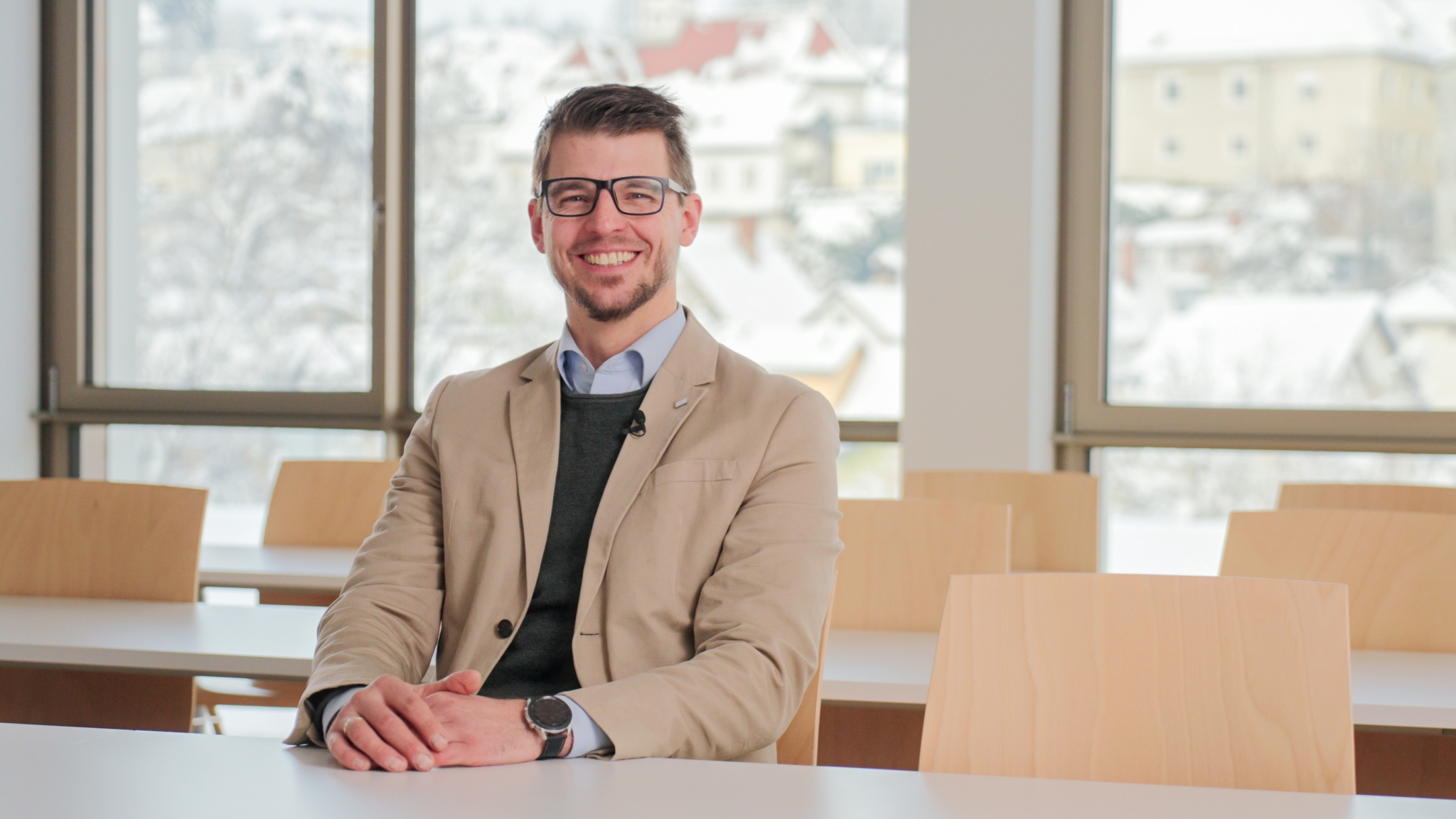 Studiengangsleiter von Agrarmanagement und -innovationen sitzt an einem Tisch in einem Seminarraum und lächelt in die Kamera