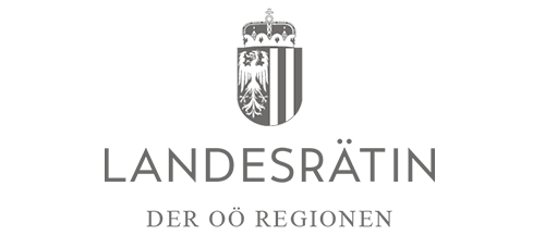 Grau-weißes Wappen von Oberösterreich, darunter steht in großen Großbuchstaben „LANDESRÄTIN“, gefolgt von etwas kleineren Großbuchstaben „DER OÖ REGIONEN“