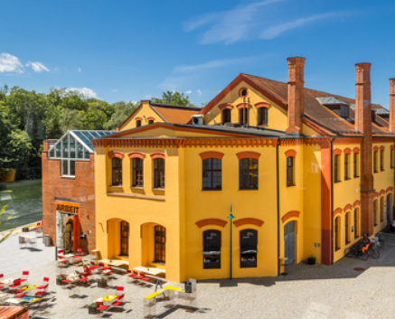 Gebäude des Museums der Arbeitswelt. Der Eingangsbereich ist gut sichtbar, davor befindet sich ein Platz mit Sitzgelegenheiten.