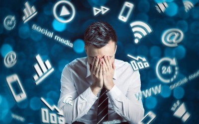 Ein Mann hält sich verzweifelt mit beiden Händen ins Gesicht. Er ist umgeben von fiktiven Darstellungen wie Smartphone, WLAN und WWW, die digitalen Stress symbolisieren