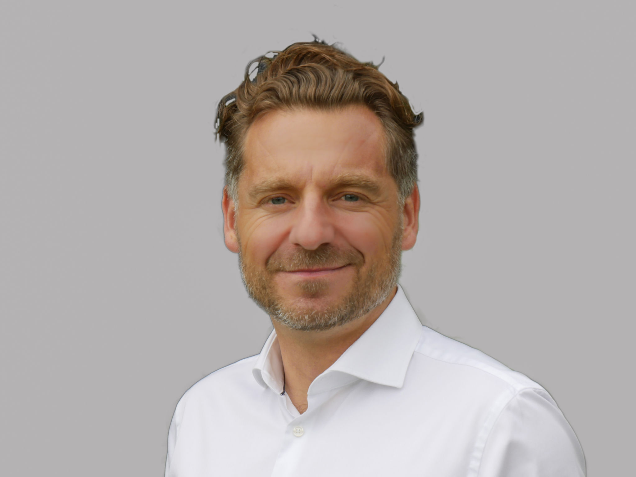 Porträtfoto von Dr. René Riedl vor weißem Hintergrund.