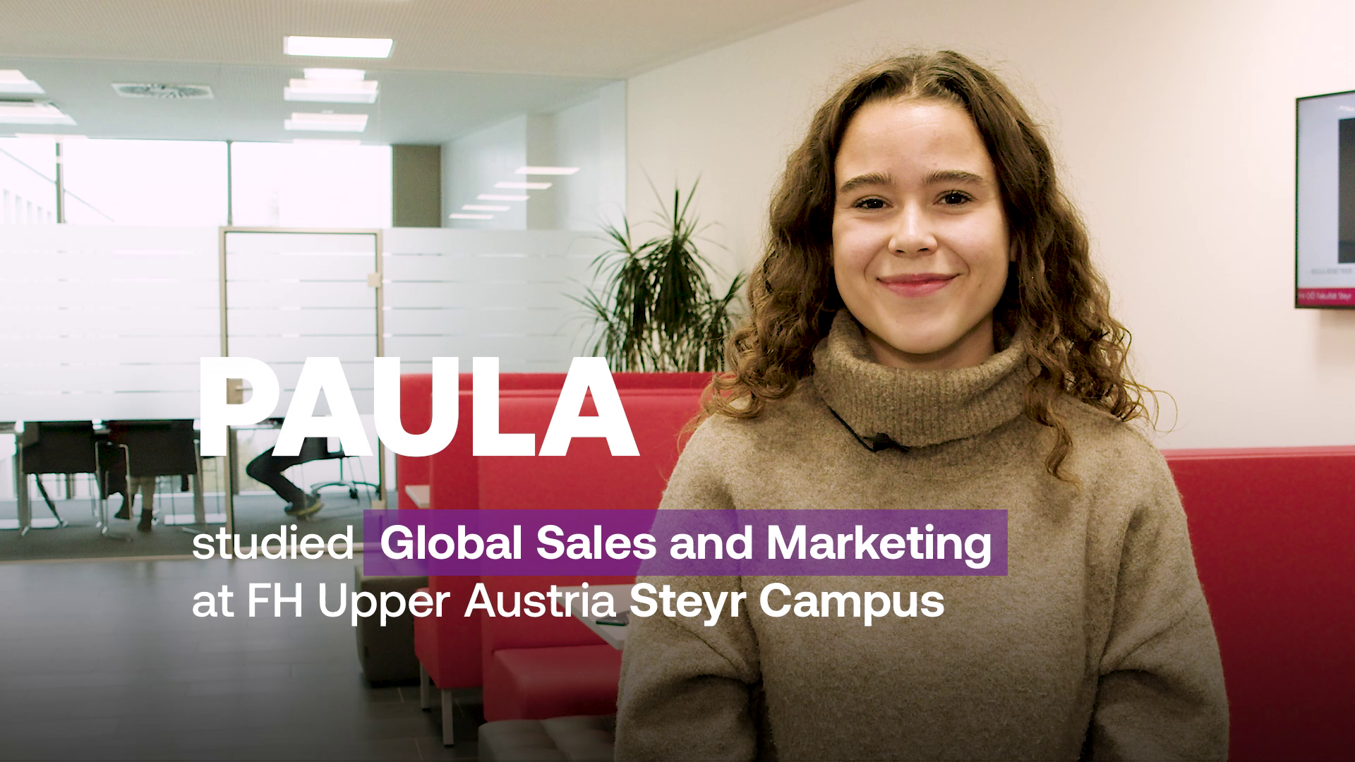 Studentin steht im FH Gebäude. Neben ihrem Bild steht groß der Name "PAULA" und darunter der Text: "studied Global Sales and Marketing at FH Upper Austria Steyr Campus"