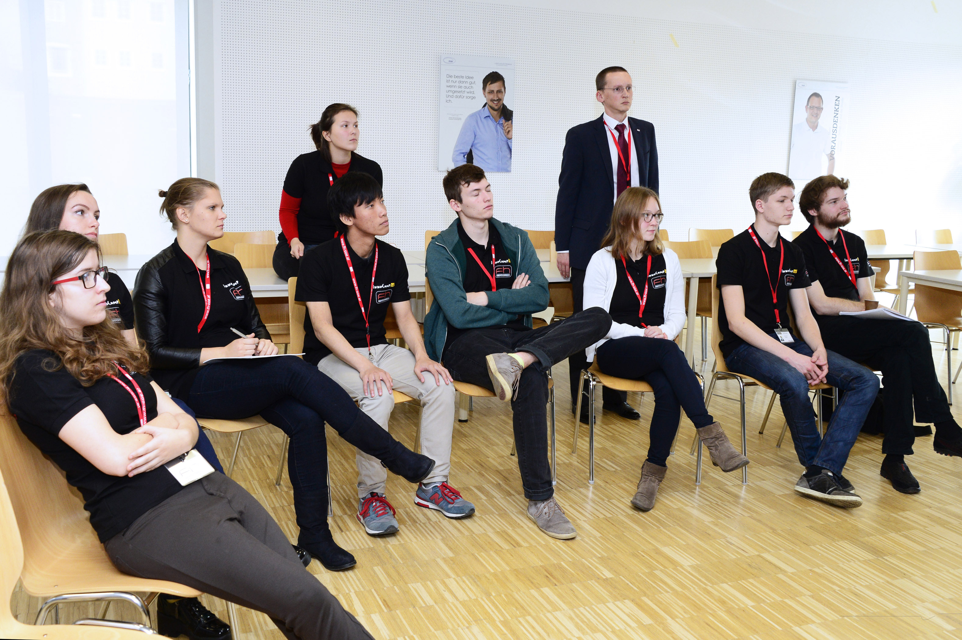 Students sit in a semi-circle in the seminar room and listen attentively.