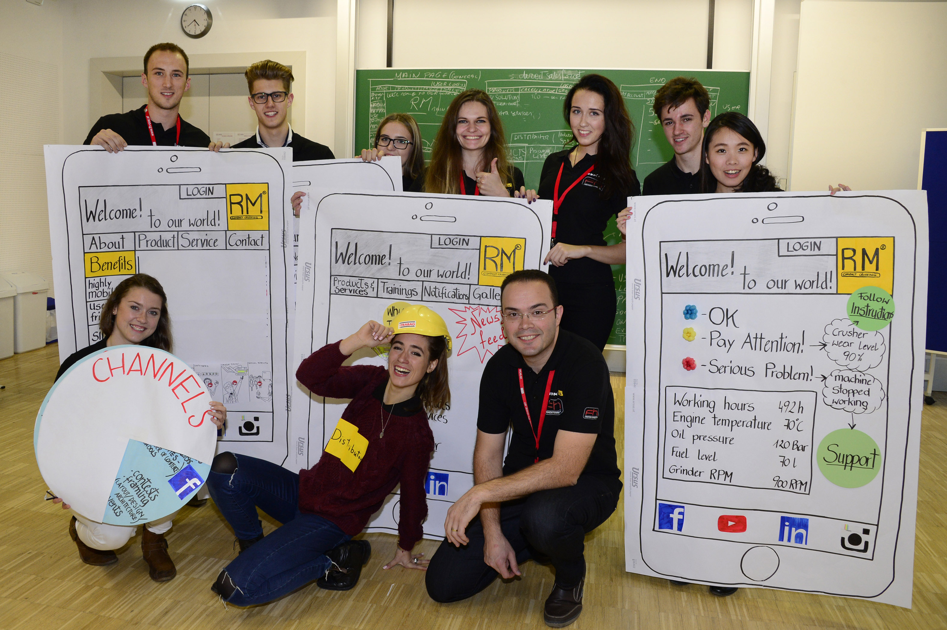 Group photo at the Innocamp: Three people squatting in front, while several others stand behind them holding flipchart presentation notes in their hands