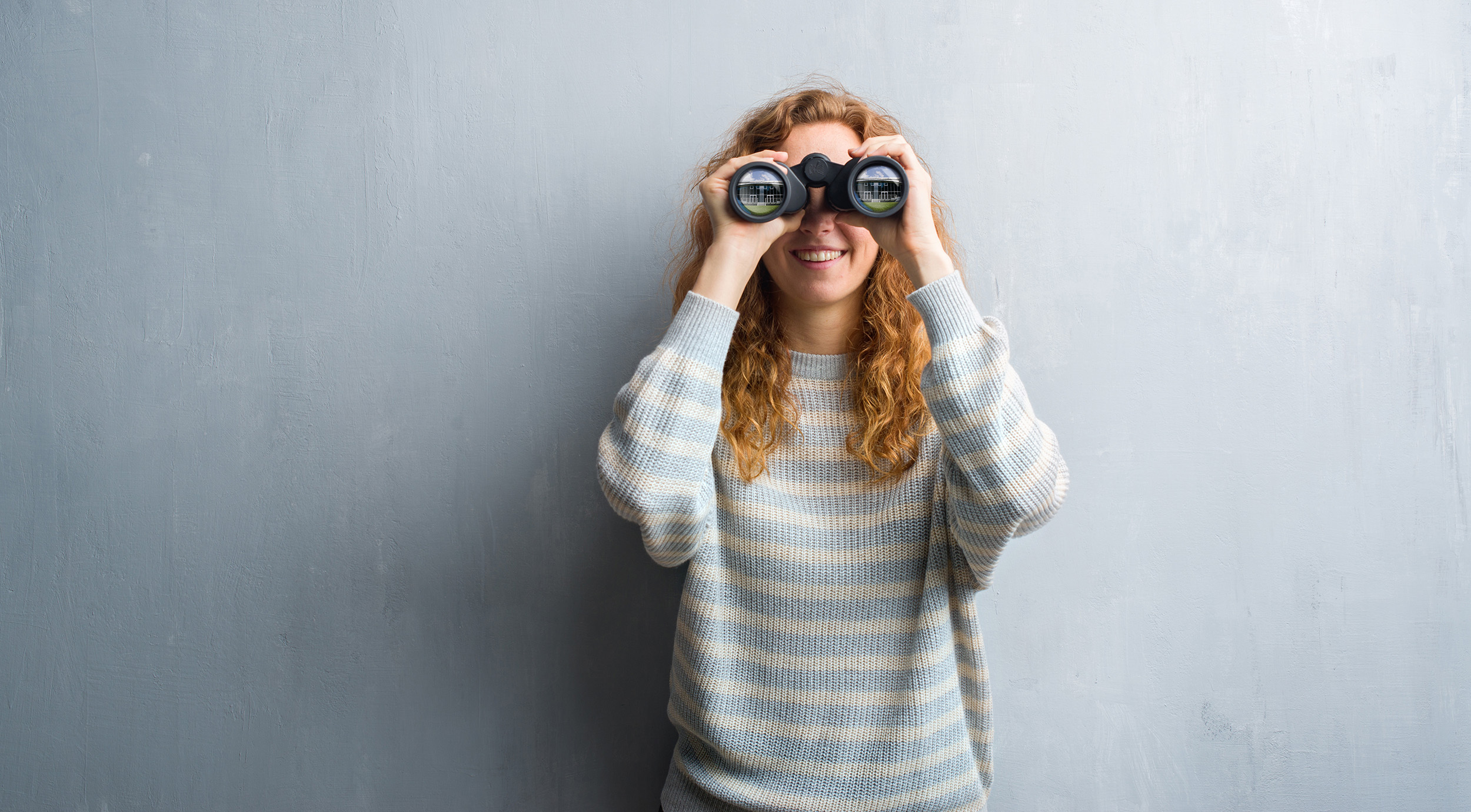 Eine Studentin hält ein Fernglas vor ihre Augen.