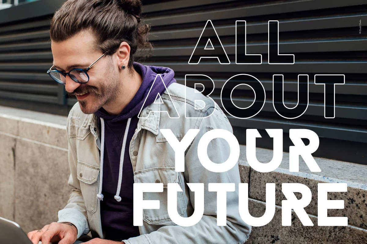 Ein junger Mann sitzt an einer Mauer und es steht in großen Buchstaben davorgeschrieben: All about your future