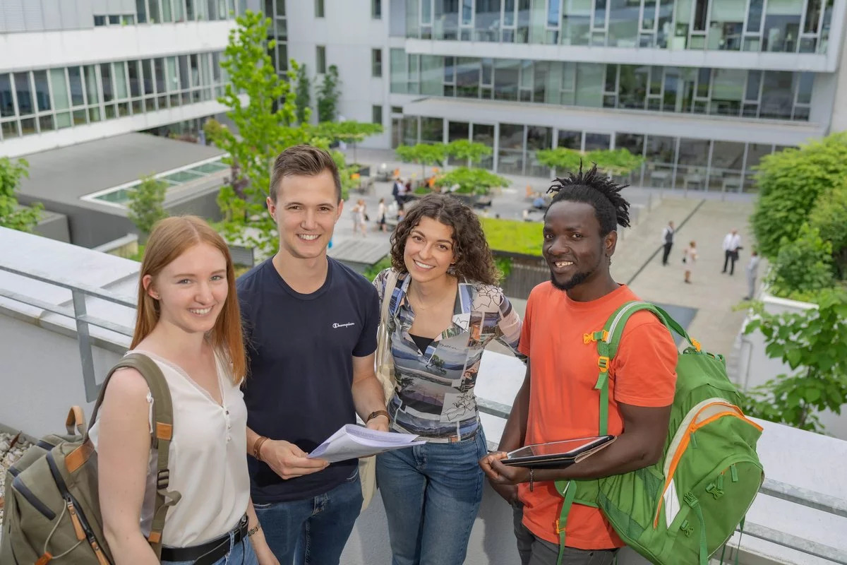 Zwei Studentinnen und zwei Studenten stehen am Campus in Wels im Freien.