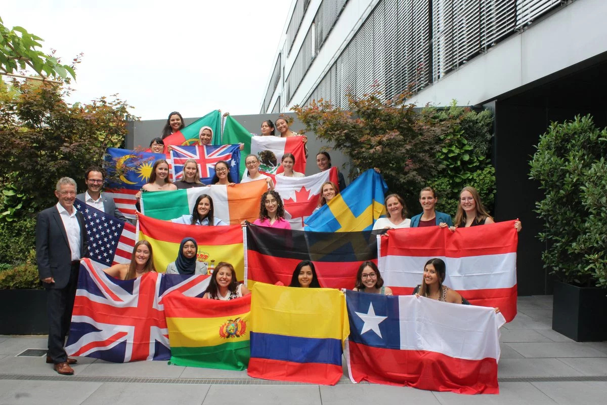 Die 22 MINT Studentinnen halten ihre Landesfahne vor sich