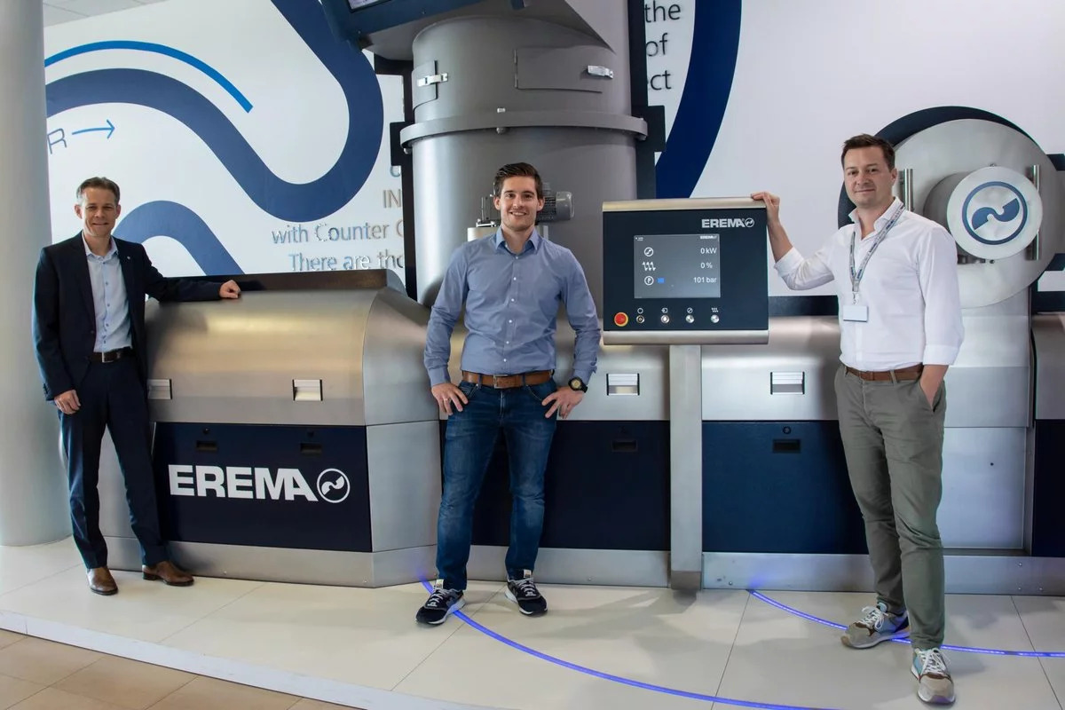 Drei Männer stehen vor einer Maschine