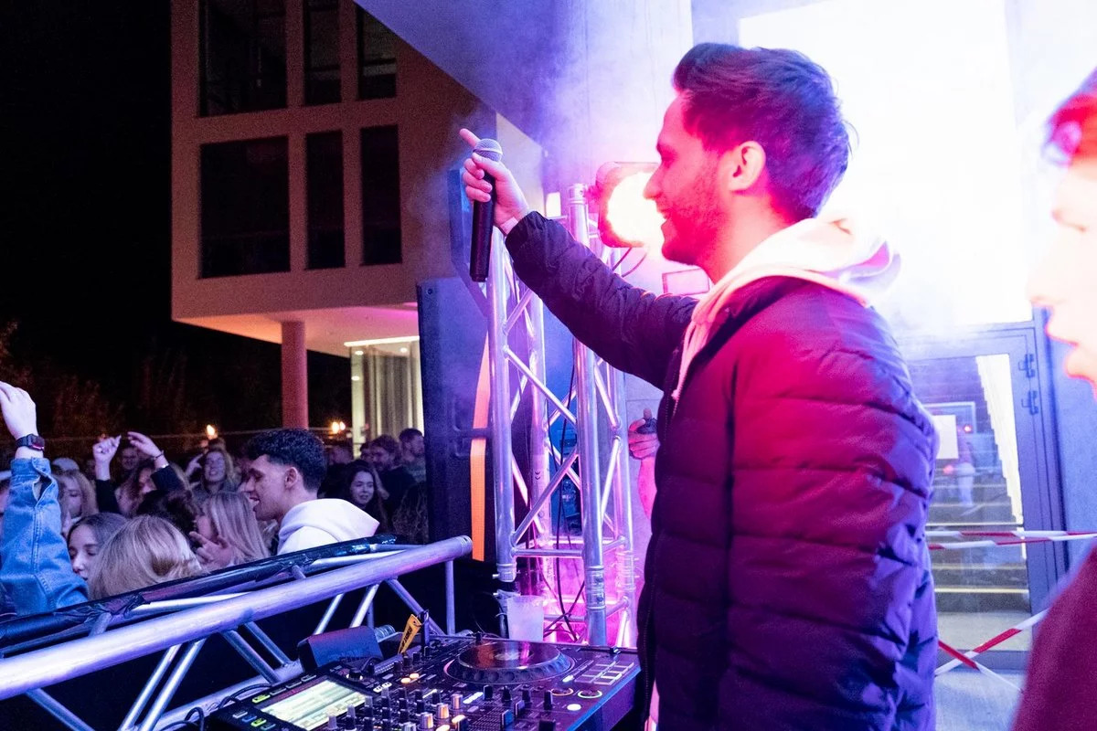 DJ mit einem Mikrofon in der Hand.