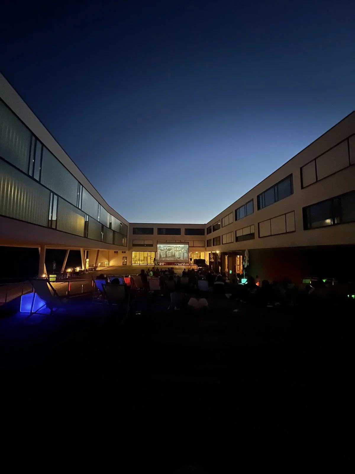 Der Innenhof des Campus Hagenberg im Dunkeln mit einer Leinwand für das Sommerkino