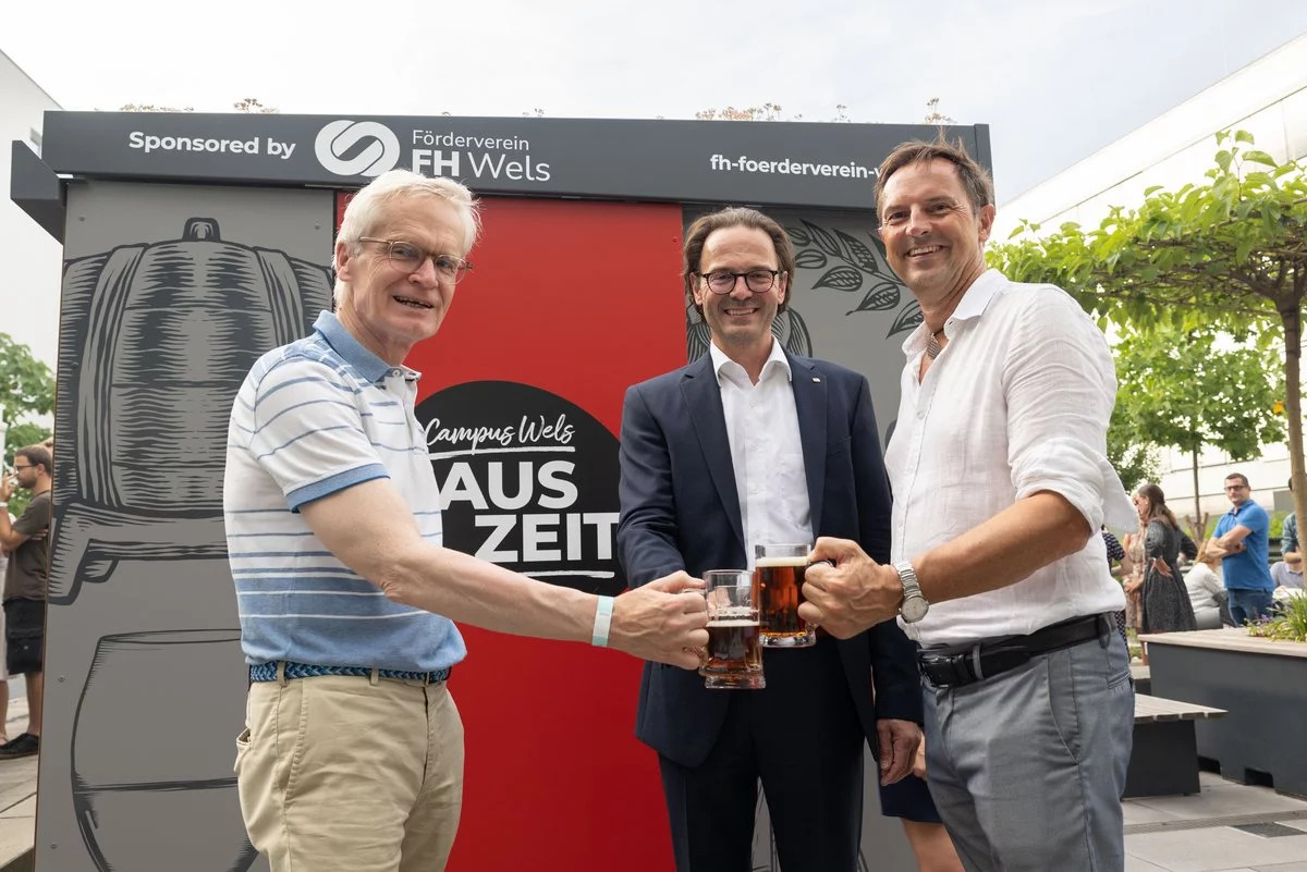 Drei Männer stoßen mit Bier an