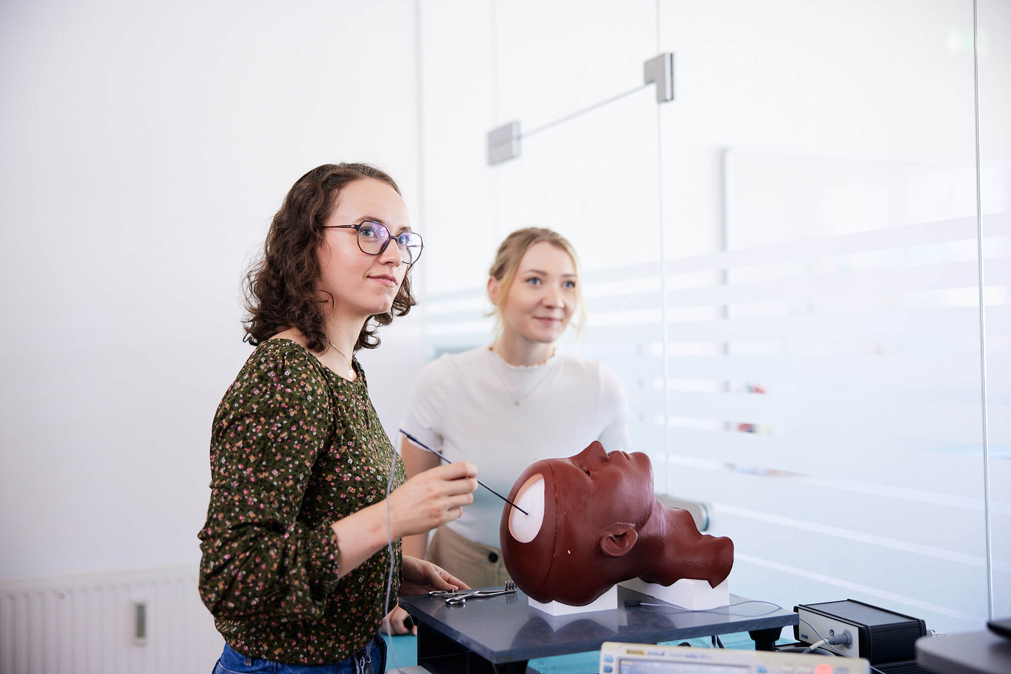 zwei junge Studentinnen arbeiten an einem Nachbau eines offenes Kopfs.