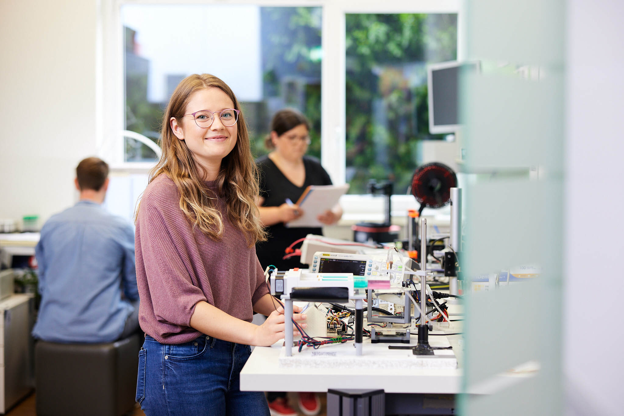 Eine junge Studentin steht in einem Technikraum der FH Linz