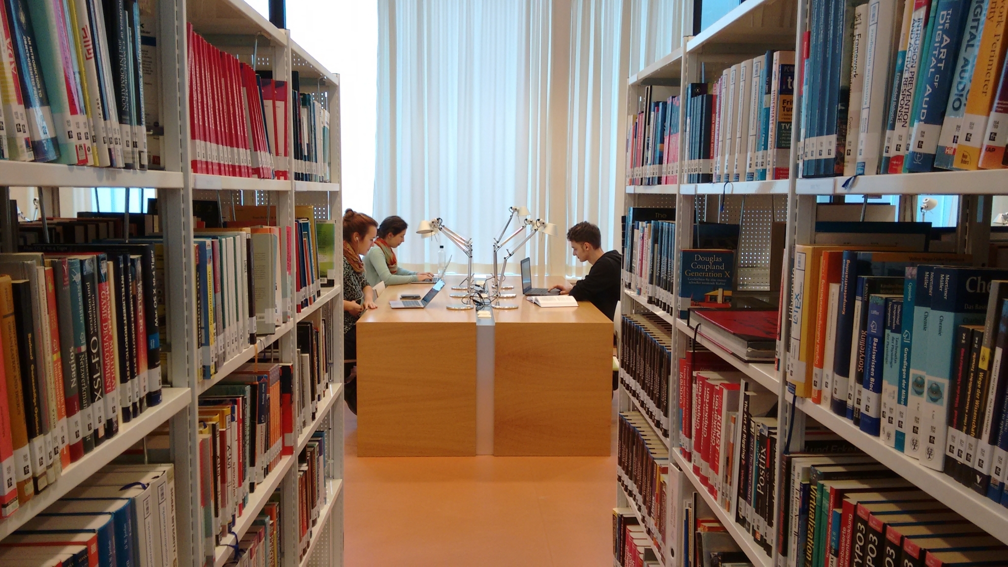 Studierende sitzen in der Bibliothek in Hagenberg.